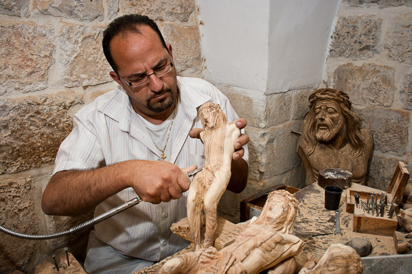 Rzemieślnik z Betlejem rzeźbi figury Jezusa w drewnie